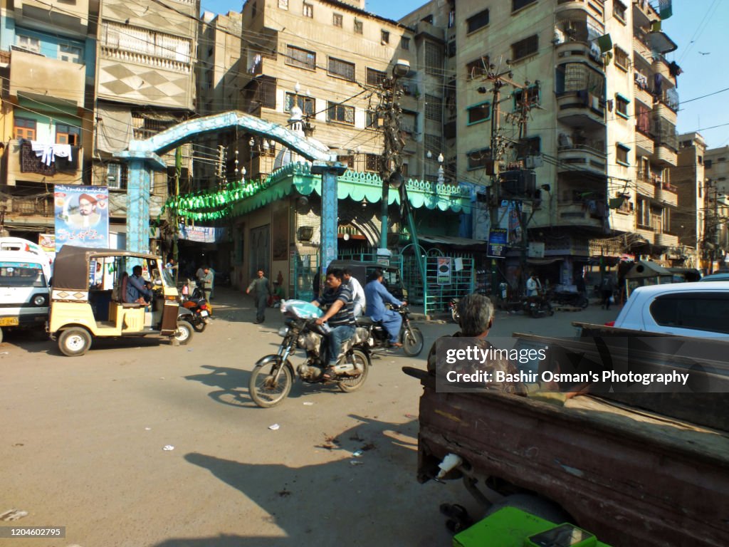 Traffic and people are moving on the Rampart Row by this old town area of Kharadar, Karachi. Kharadar is the prime locality of the city which was a walled compound inhibiting people of the time inside who were mostly from the Hindu community.  Tow of the main gates were opening towards sea and a stream flowing proximate to the area.  One which was opening towards the sea was named as KHARADAR and the other gate facing the flowing stream was named as MITHADAR.