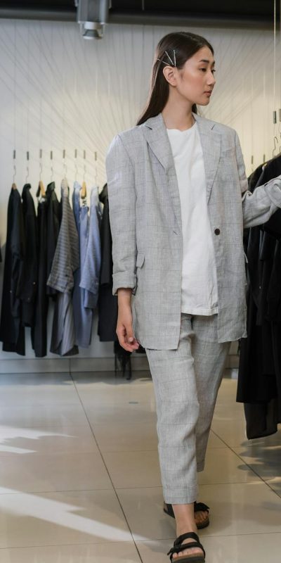 Young woman browsing clothes in modern fashion boutique.
