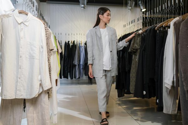 Young woman browsing clothes in modern fashion boutique.